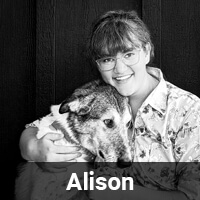 A person wearing glasses and a floral shirt smiles while hugging a large dog. The person is in front of a dark background. The name "Alison" is displayed at the bottom of the image.