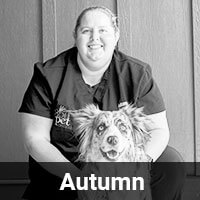 A person in a dark uniform smiles while kneeling next to a dog with a spotted coat. The image is in black and white, and the word "Autumn" is displayed at the bottom.