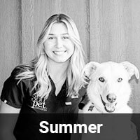 A woman with long hair smiling next to a white dog. They are both in front of a plain backdrop. The word "Summer" is written at the bottom of the image.